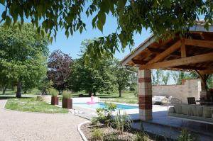 a woman sitting in a pool in a garden at Le Refuge de Labastide - Charme & Sérénité in Labastide-de-Lévis