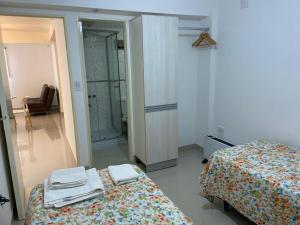 1 Schlafzimmer mit 2 Betten und einer ebenerdigen Dusche in der Unterkunft Temporario 9 de Julio Santiago del Estero in Santiago del Estero