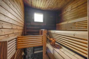 a sauna with wooden walls and a window at Holiday Apartment Lomahimos 10 in Himos