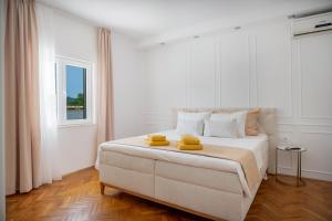 a white bedroom with a bed with yellow towels on it at Holiday House Ivan with heated pool in Neorić +43 photos