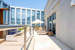 a balcony with chairs and an umbrella on a building at Hotel VISION in Brasilia