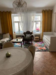 Una sala de estar con una mesa y una lámpara de araña. en Apartman Modrý dom, en Levoča