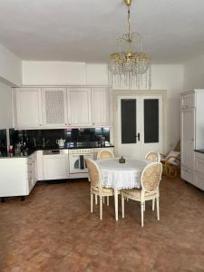 a kitchen with a table and chairs and a chandelier at Apartman Modrý dom in Levoča
