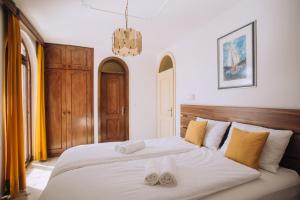 a bedroom with a large white bed with two towels at Villa Purić in Rovinj