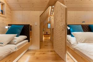 a room with three beds in a wooden house at Luxury Chalet & Sauna Kati - Velika Planina - I Feel Alps in Stahovica