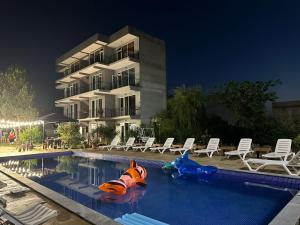 una piscina con noodle da piscina di fronte a un edificio di Pirosmani a Kobuleti