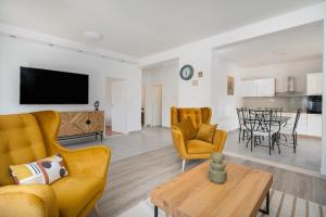 a living room with yellow chairs and a table at Holiday House Ivan with heated pool in Neorić