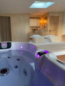 eine lila Badewanne in einem Zimmer mit einem Bett in der Unterkunft Loveness Suite & Spa in Aigues-Mortes