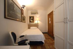 a small room with a bed and a table and chairs at Hotel Locanda Cairoli in Rome