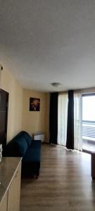 ein Wohnzimmer mit Couch und großem Fenster in der Unterkunft Dream Holiday apartment in Bansko