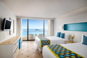 a hotel room with two beds and a view of the ocean at Sunscape Dorado Pacifico Ixtapa Resort & Spa- All Inclusive in Ixtapa +60 photos
