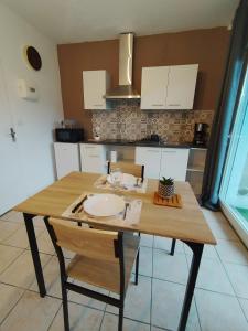 a kitchen with a wooden table with two chairs at grand studio in Limoges +3 photos