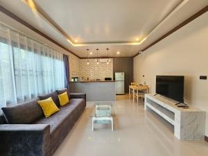 a living room with a couch and a television at Bang Po Hut in Ban Bang Po