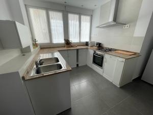 a white kitchen with a sink and a stove at Luxury apartment close to everything in Granada