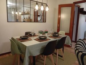 a dining room with a table with chairs and a chandelier at Acogedor piso en Maliaño in Camargo +40 photos