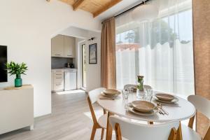 a kitchen and dining room with a white table and chairs at Morze Ciszy in Dziwnów +22 photos