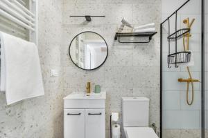 a white bathroom with a mirror and a toilet at Morze Ciszy in Dziwnów