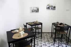 a room with three tables and chairs with cups on them at B&B Nanze' e Rete' - Esperienze Pugliesi in Carosino