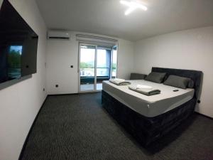 a bedroom with a large bed and a large window at Villa XY in Blagaj