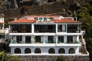 een groot wit huis met een rood dak bij Bahía Apartments in Icod de los Vinos