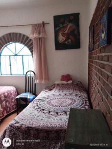 a bedroom with a bed and a brick wall at Casa Ecológica Pablo in Curva La Pera +6 photos