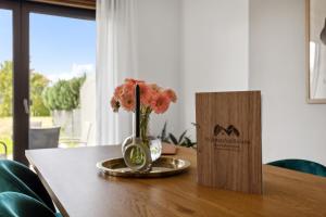 un vase de fleurs sur une table à côté d'une boîte dans l'établissement Ferienhaus-Terrassen-Parkplatz, à Cobourg