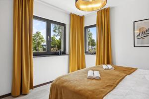 a bedroom with a bed with two white slippers on it at Ferienhaus-Terrassen-Parkplatz in Coburg
