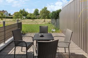 un patio avec quatre chaises et une table et une clôture dans l'établissement Ferienhaus-Terrassen-Parkplatz, à Cobourg 22 autres photos