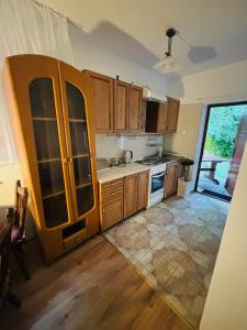 a kitchen with wooden cabinets and a large window at VILLA BIAŁA in Okuninka