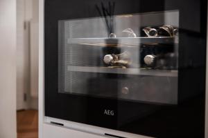 a microwave oven with a bunch of dishes in it at Sejoylia Knokke: app 2ch luxueux au centre de KH in Knokke-Heist