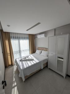 a white bedroom with a bed and a cabinet at Villa Begonvil in Kuşadası +30 photos