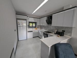 a kitchen with white cabinets and a counter top at Villa Begonvil in Kuşadası
