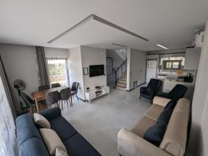 a living room with a couch and a dining room at Villa Begonvil in Kuşadası