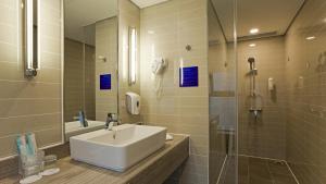 ein Bad mit einem Waschbecken und einer Dusche in der Unterkunft Holiday Inn Express Xi'an High-Tech Zone, an IHG Hotel in Xi'an