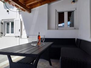 a wooden table with a bottle of wine and two glasses at Sea balcony in Marathokampos +15 photos
