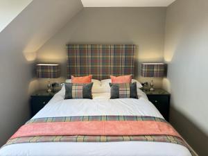 a bedroom with a large bed with pillows at Victoria Cottage, Cullercoats in Cullercoats