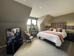 a bedroom with a bed and a flat screen tv at Victoria Cottage, Cullercoats in Cullercoats