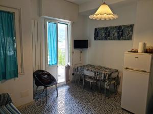 a kitchen with a table and a refrigerator and a window at Bilocale vicinissimo 50m mare in Levanto