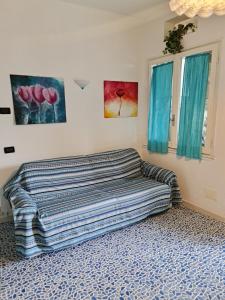 a couch in a room with two paintings on the wall at Bilocale vicinissimo 50m mare in Levanto