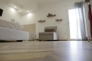 a white room with a bed and a chair at B&B Nanze' e Rete' - Esperienze Pugliesi in Carosino