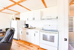 een keuken met witte kasten en een witte koelkast bij Beachfront Cabin #5- Maijac Resort & Marina in Magnetawan
