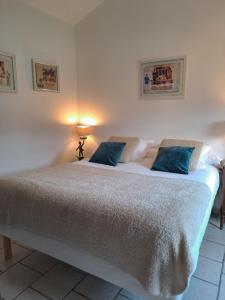 a bedroom with a large white bed with blue pillows at Chambres d hotes near Mâcon with secure Parking in Grièges