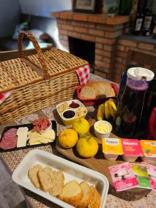ein Tisch mit Brot und Obst und einem Korb mit Lebensmitteln in der Unterkunft Quarto Coralina - Bio Cult in Campo Alegre
