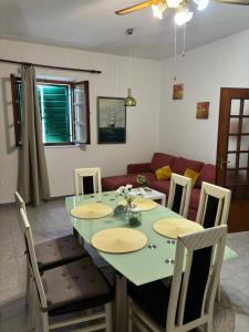 a dining room with a table and chairs and a couch at Apartments Renata in Pučišća