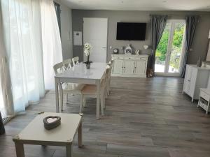 a dining room with a table and a tv on the wall at Maison confortable à La Ciotat avec terrasse privée in La Ciotat