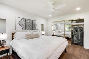 a white bedroom with a large bed and a mirror at Quaint Flagstaff Condo with Balcony about 6 Mi to Dtwn! in Flagstaff +26 photos