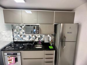 a small kitchen with a refrigerator and a sink at Lindo Apartamento in Brasília +1 photo
