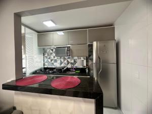 a kitchen with a counter with red mats on it at Lindo Apartamento in Brasília