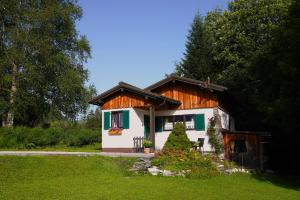 a small white house with a wooden roof at Ferienhaus Romantika in Bad Aussee