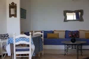 a living room with a blue couch and a table at Sérénité Marine in Fnidek